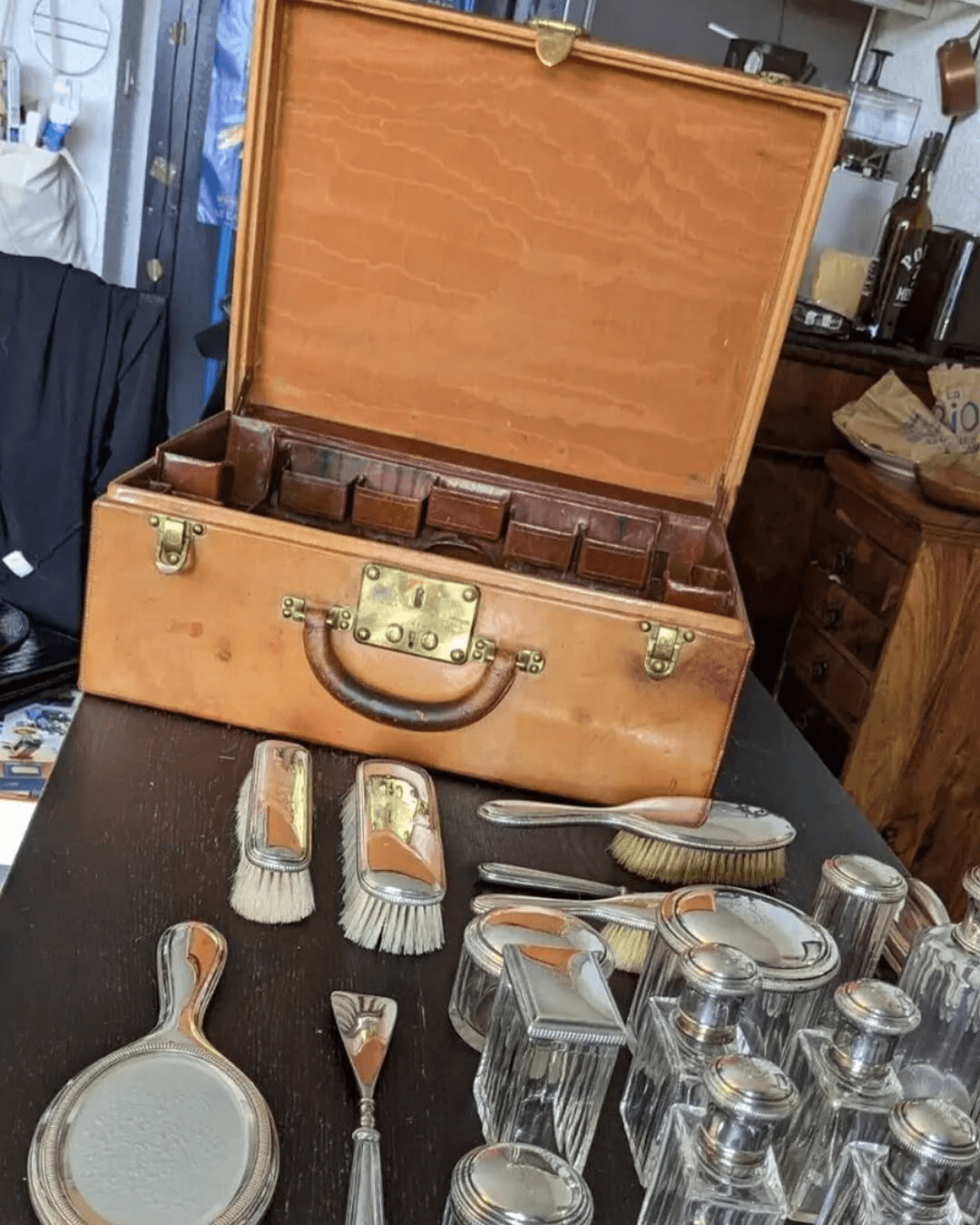 Vintage Louis Vuitton case open, with hairbrush and accessories laid out on display