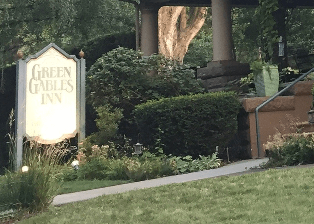 Sign for the Green Gables Inn surrounded by greenery and landscaping.